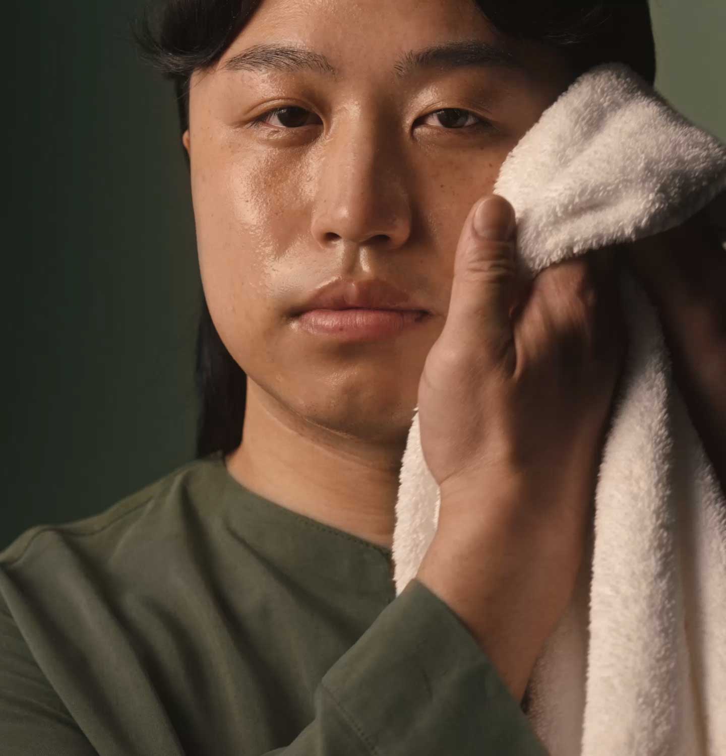 An individual gently wiping the face with a facial towel