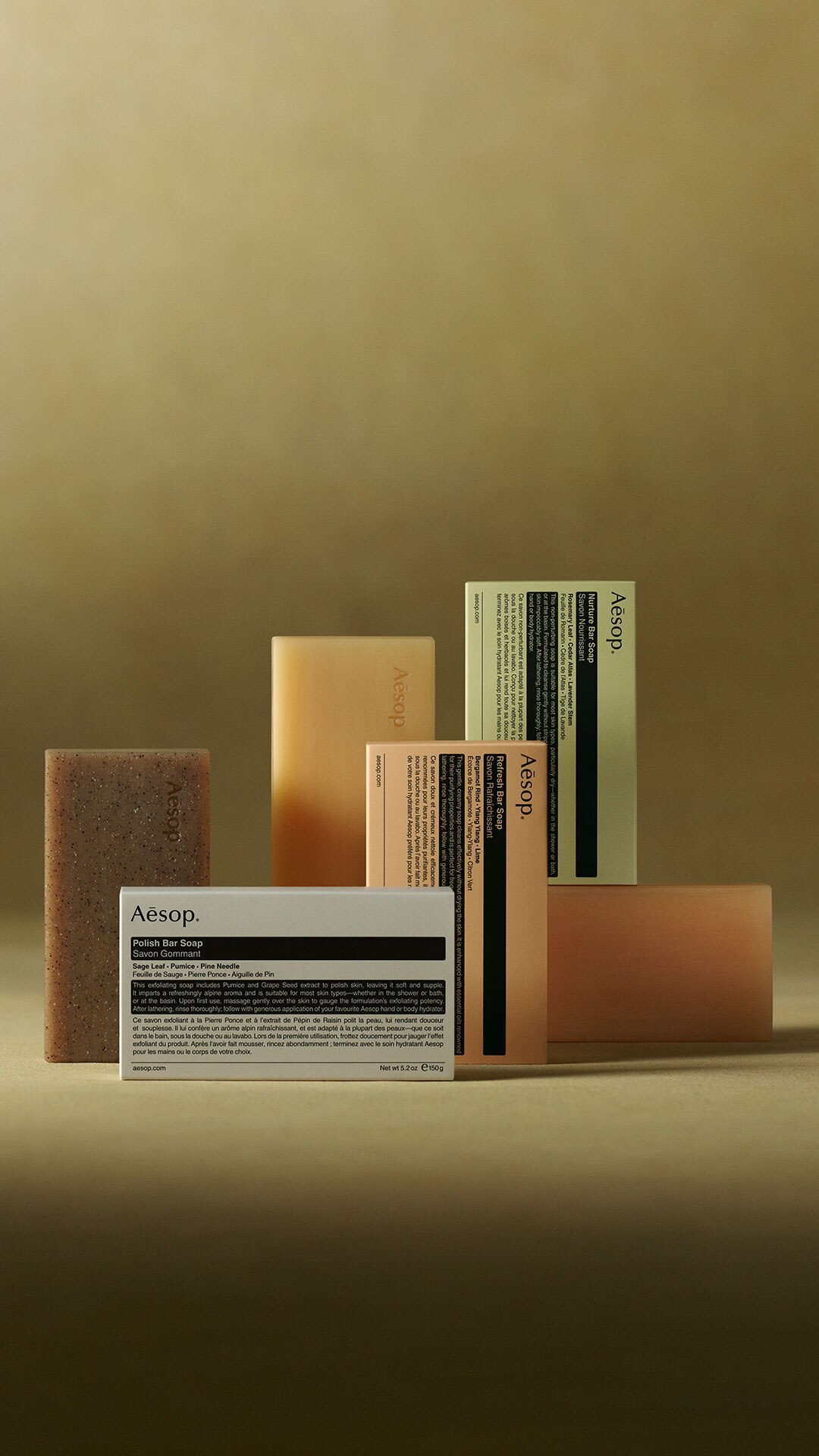 Aesop bar soaps placed next to each other on a green textured background