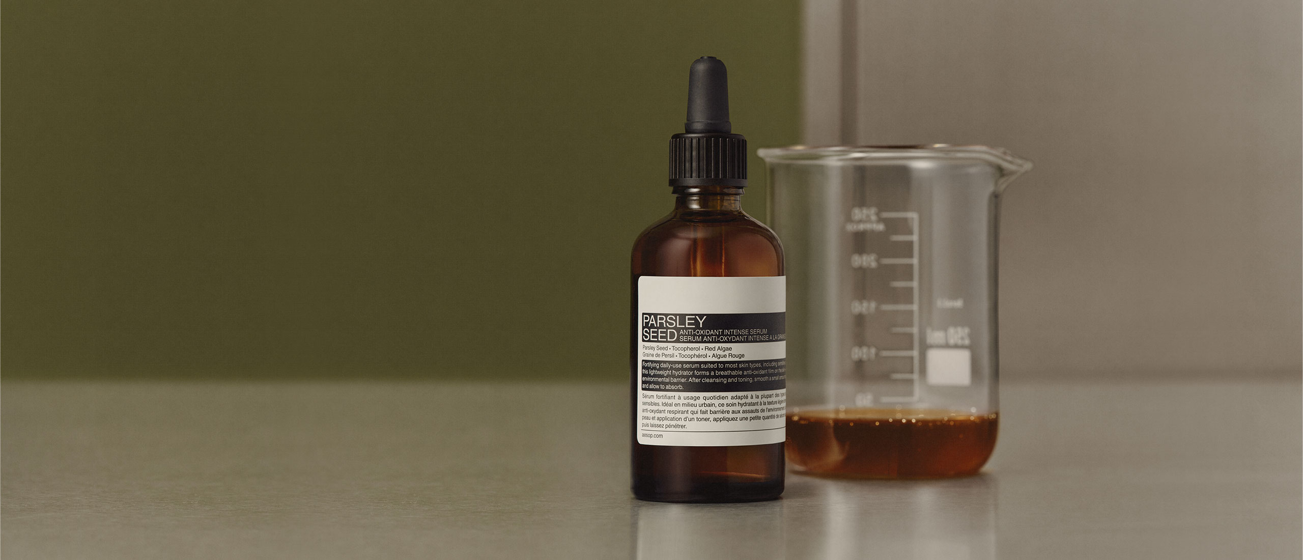 Parsley Seed Anti-Oxidant Intense Serum placed next to a beaker