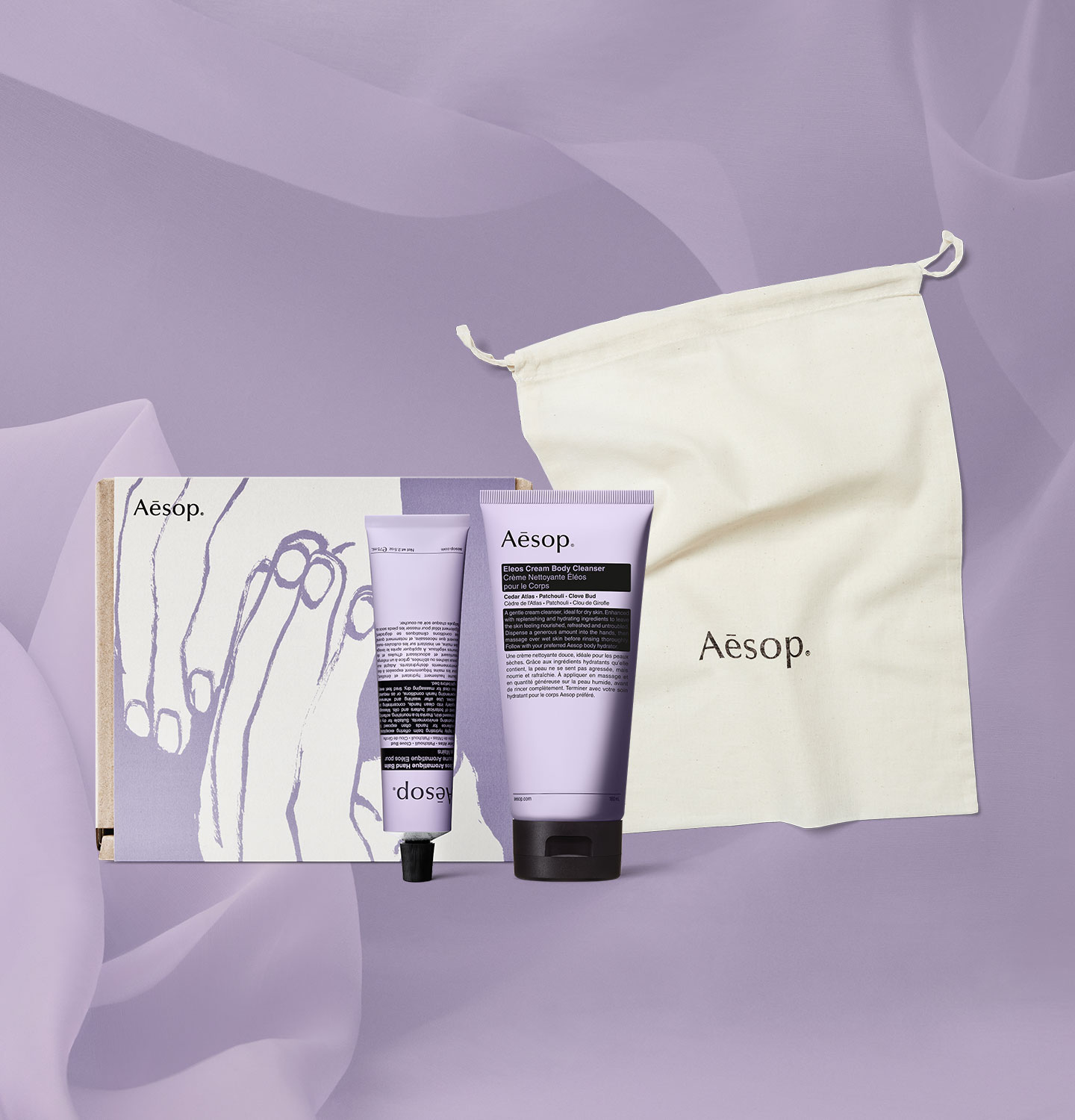 Eleos Cream Body Cleanser and Eleos Aromatique Hand Balm alongside Eleos sleeve cardboard box with Aesop cotton bag.